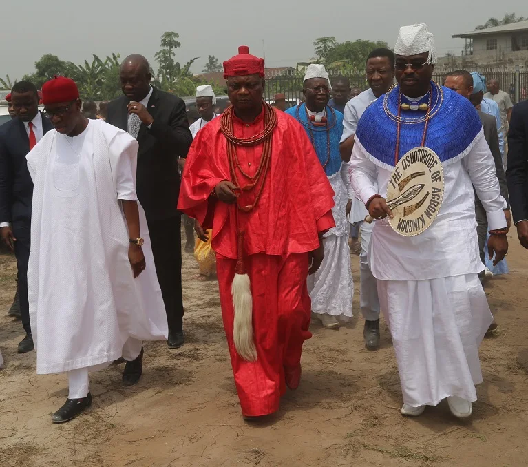 Royal procession at an Agbon Day celebration: the Ovie of Agbon in red royal regalia walking with the then Governor of Delta State, Senator (Dr) Ifeanyi Okowa, and Chief Lovette Idisi